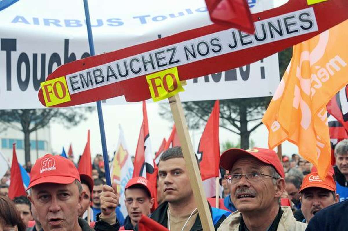 Airbus employees demonstrate in Toulouse, France, in front of the entrance of their company to ask for better raises. The banner in the center reads "Give jobs to our young people."