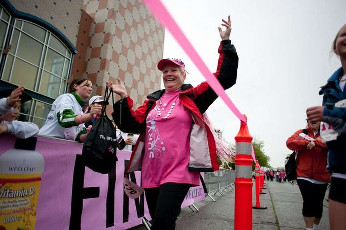 A woman is greeted at the finish line with cheers and high-fives during the 17th Annual Komen Puget Sound Race for the Cure in Seattle on June 6, 2010.