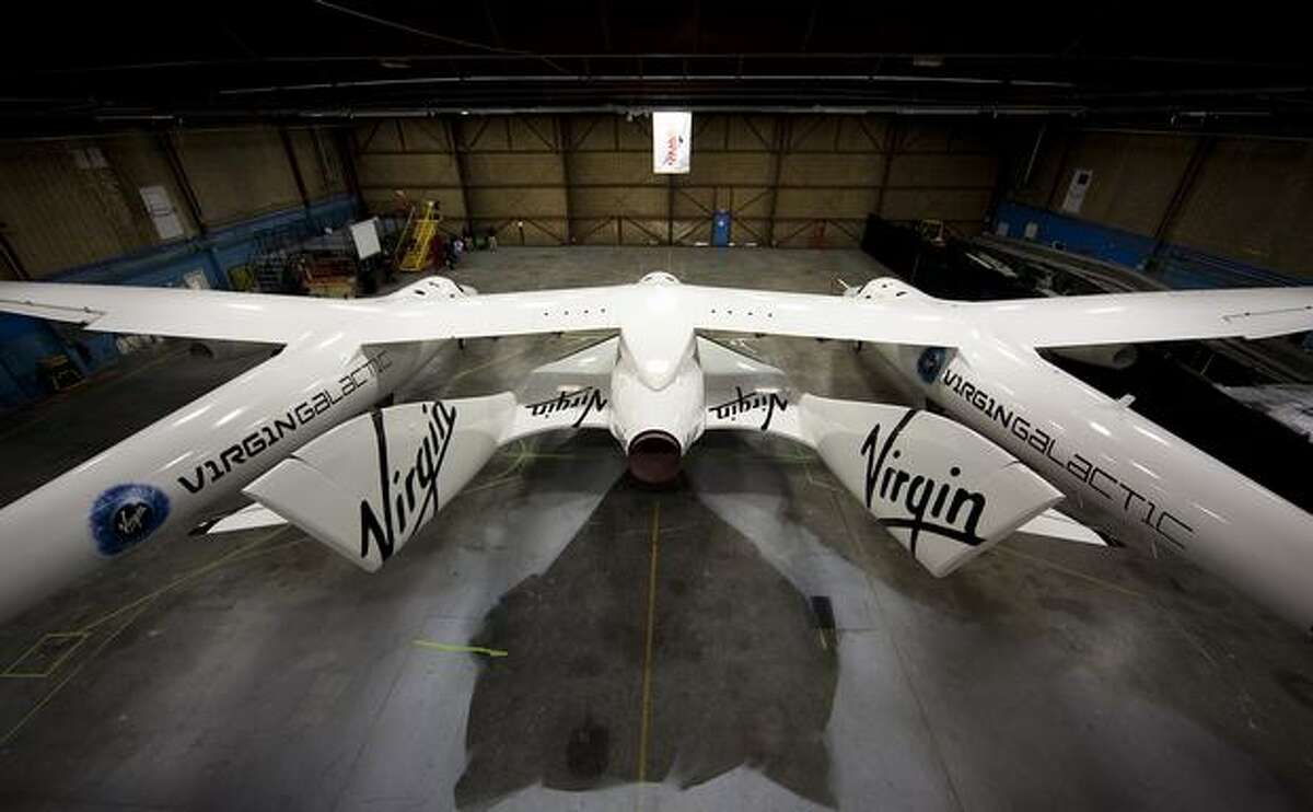 Virgin Galactic's SpaceShipTwo beneath White Knight Two, which will ferry SpaceShipTwo to launch altitude, on Dec. 7, 2009 at the Mojave Air and Space Port in Mojave, Calif. (Virgin Galactic photo)