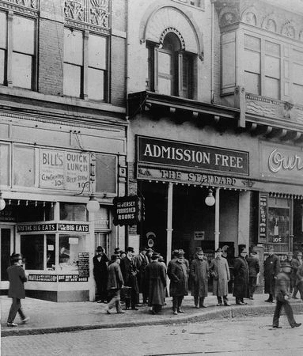 The original P-I caption for this photo read: Occidental St. was "uptown" in 1902 when admission was free to a penny arcade, waffles and coffee sold for 10 cents at Bill's Quick Lunch and so did a big bowl of beef stew.