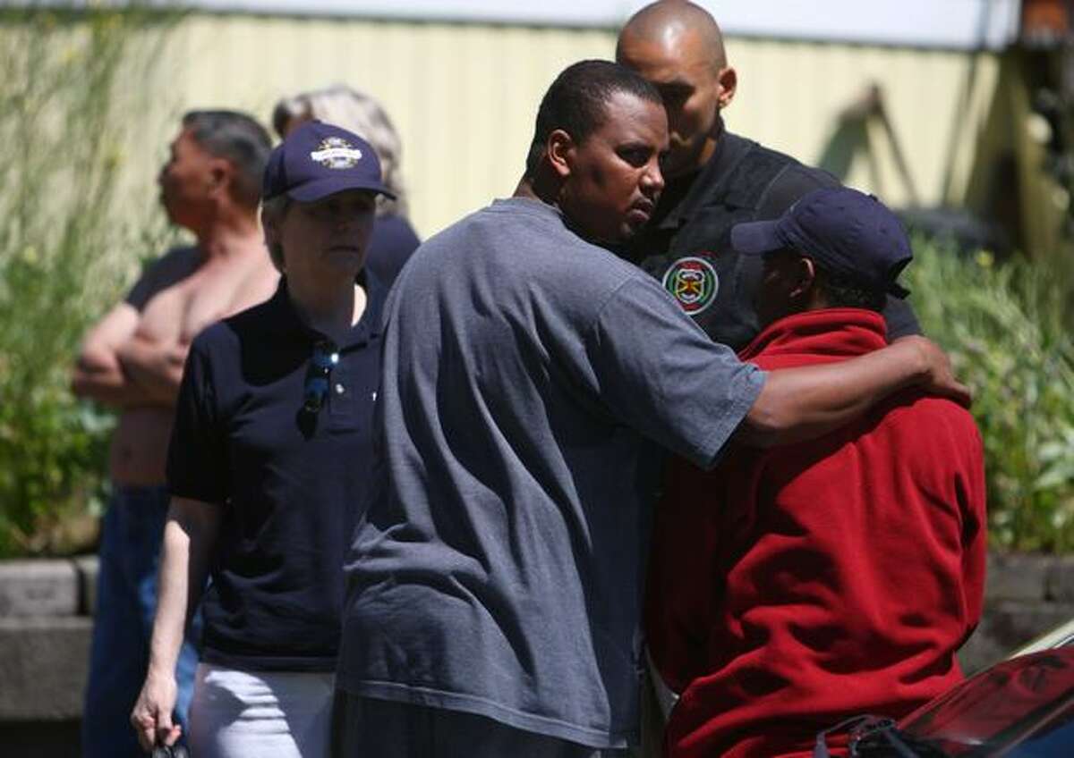 A man is comforted after a fire in an apartment building killed five people in Fremont. It was reported that children were among the dead in the fire.