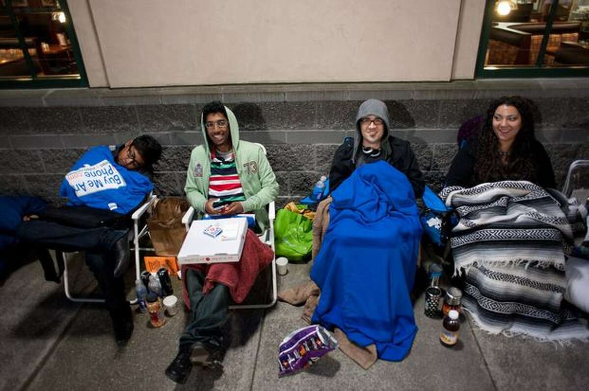 From left to right: Flo Wsion, Matt Saba, Jay Wade and Tanya Hemion wait in line for the new iPhone at the Apple store at University Village in Seattle. They started waiting at 10 p.m. on Wednesday.