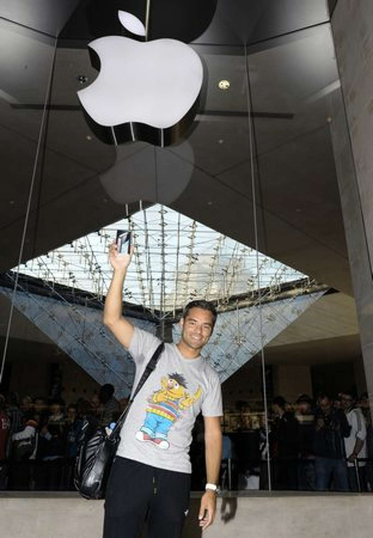 Maurice holds his new iPhone 4 in front of a mobile-phone store at the Carrousel du Louvre shopping mall in Paris on June 24, 2010.