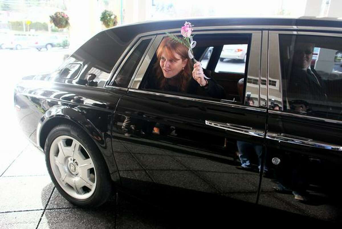 Sarah Ferguson, the Duchess of York, waves to her admirers from a Rolls Royce during a visit to Aegis Living of Shoreline on Tuesday. The Duchess was in town to speak at the Aegis Living Annual Meeting. She also wanted to meet some of the residents of the senior communities.