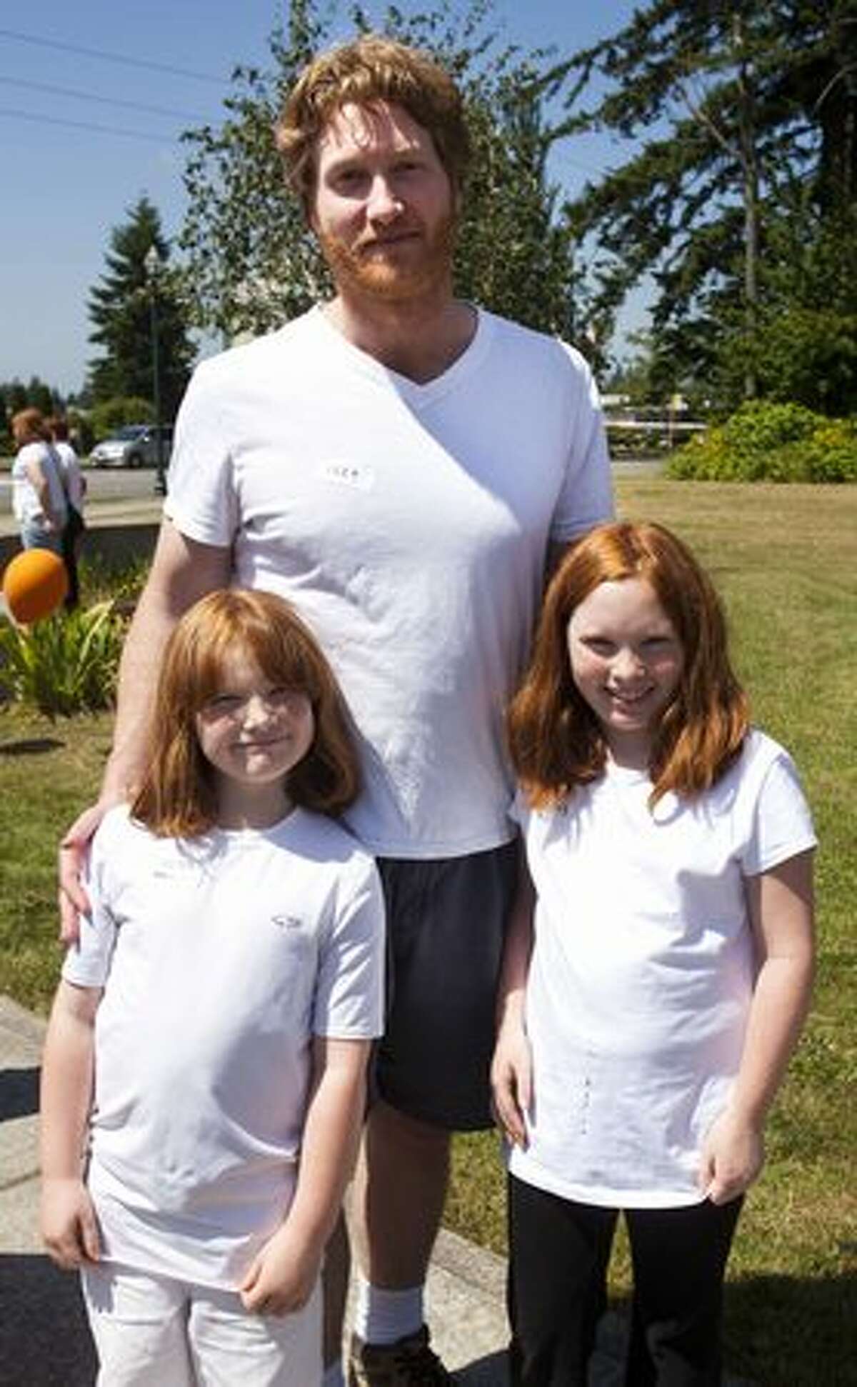 Molly, 7, Megan, 10, and Rob McAdams wait in line for Redheads and More Redheads Day.