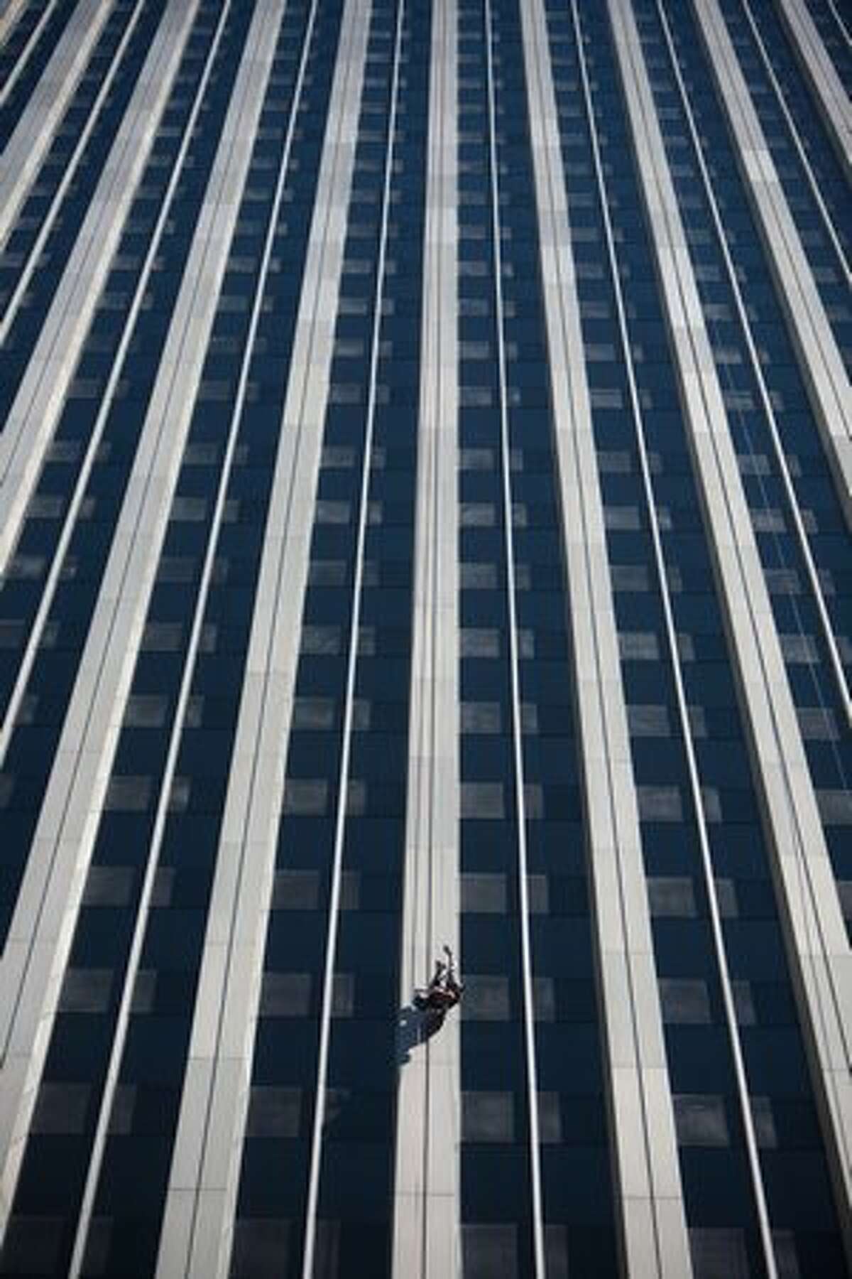 Mandy Crayton hangs upside down during "Over the Edge," a fundraiser for Special Olympics Washington. Crayton usually works in the skyscraper but on Saturday she was one of 112 people scheduled to rappel off the 40 story Rainier Tower.