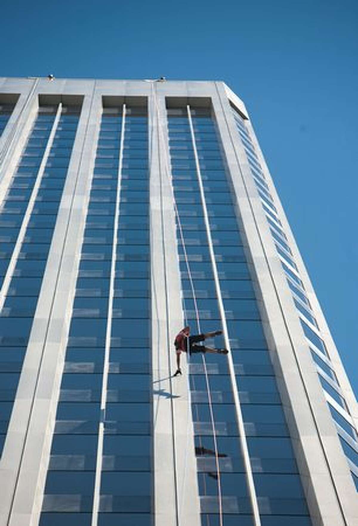 A rappeller reaches out to touch the building during "Over the Edge," a fundraiser for Special Olympics Washington. To earn a spot, rappellers had to raise $1,000 for Special Olympics Washington.