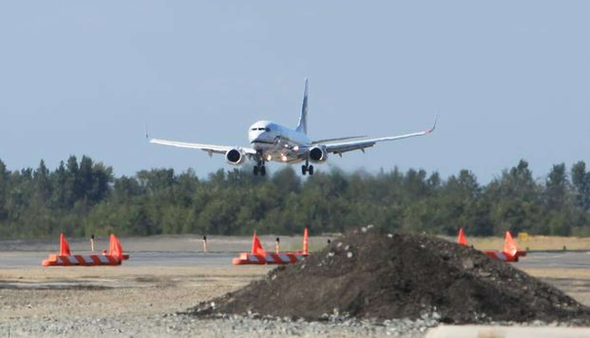 An Alaska Airlines plane lands near one of the construction projects at Bellingham International Airport.