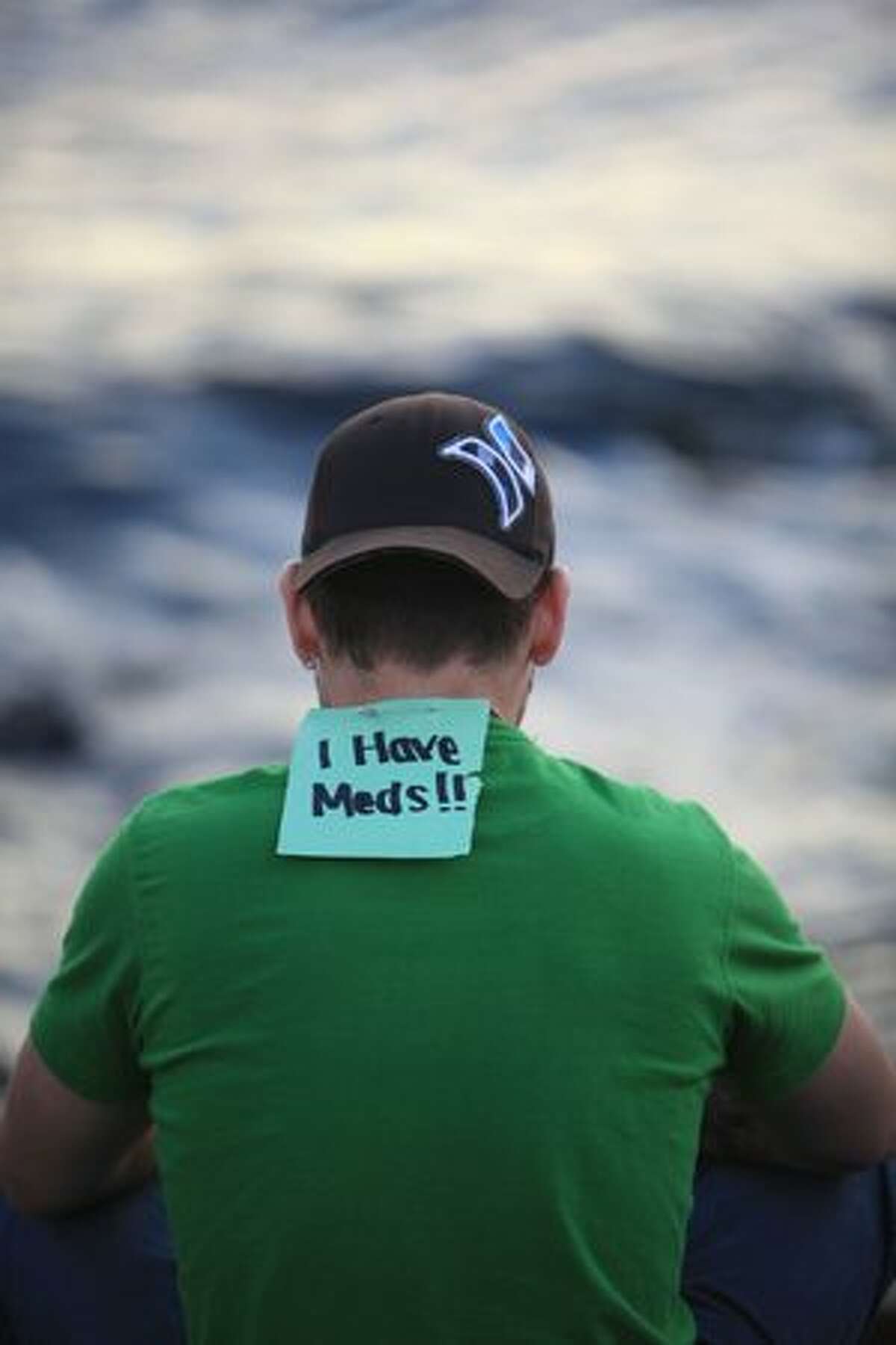 A participant sits near the water during Seattle's Hempfest.