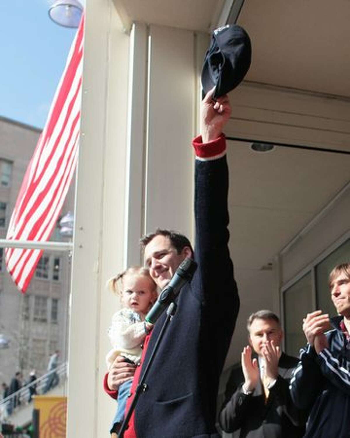 Luger Christian Niccum waves to the crowd as he holds his daughter Hayden Lulu Niccum as local Olympians are welcomed home after competing in the Vancouver Olympics.