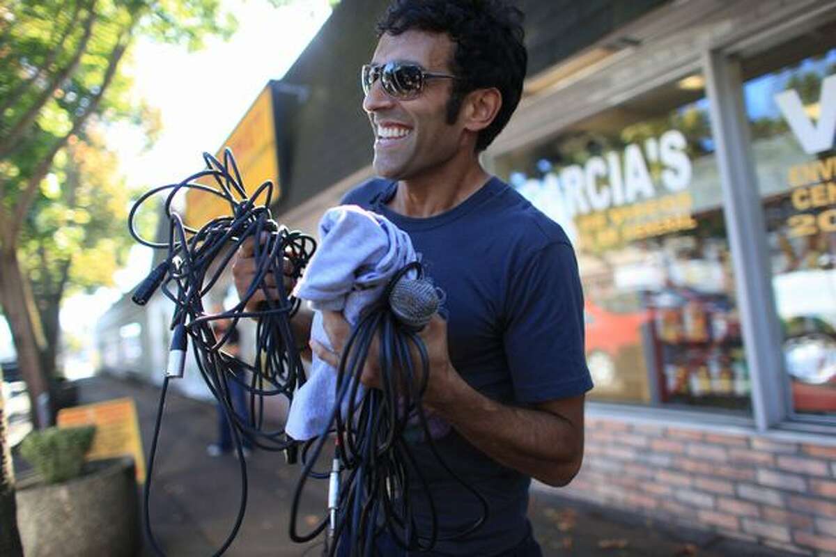 Lou Trez, vocalist for the band Quickie, tries to keep his mic cable from getting tangled during a whirlwind tour from Everett to Seattle. The band tried to break a world record by playing 48 mini-concerts in one day. The band had just performed at Lake City's Back Door Pub and the nearby dive bar Rimrock Steakhouse. Photographed on Thursday, September 30, 2010.