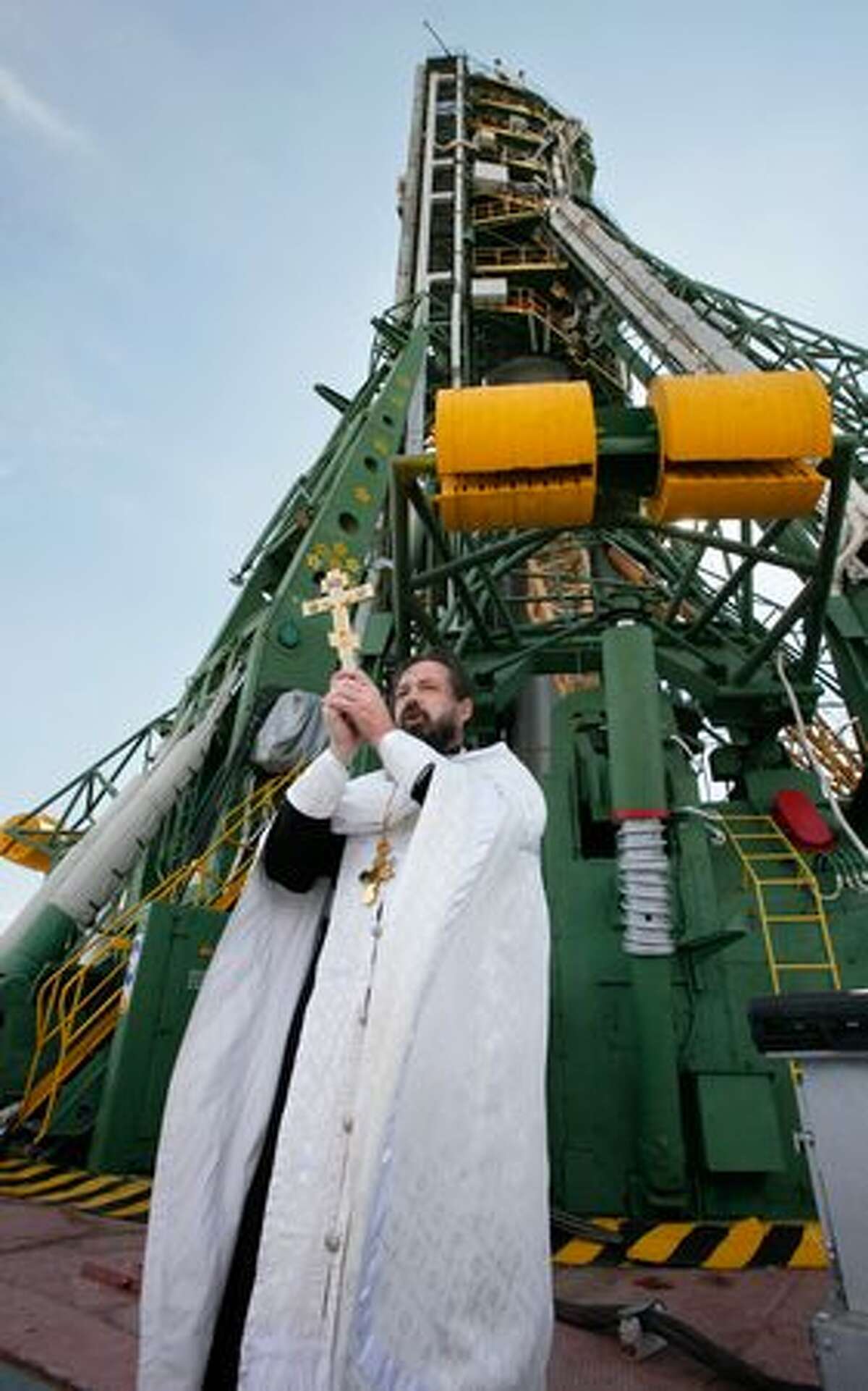 An Orthodox priest blesses specialists and the Russian Soyuz TMA-01M spacecraft that will carry a new crew to the international space station at the launch pad at the Russian leased Baikonur cosmodrome in Kazakhstan, on October 6, 2010.