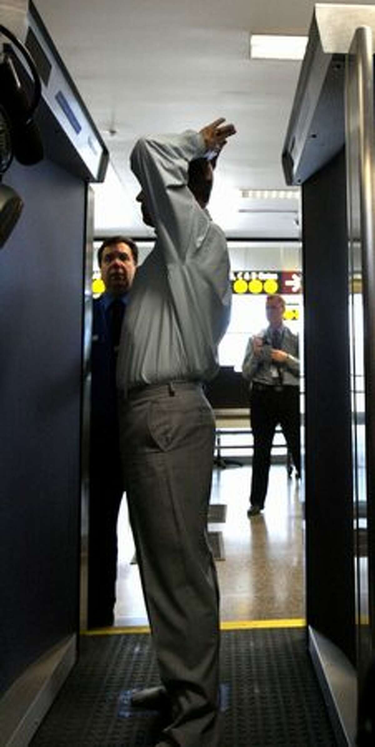 A Transportation Security Administration employee demonstrates a backscatter X-ray body scanner at Sea-Tac Airport.