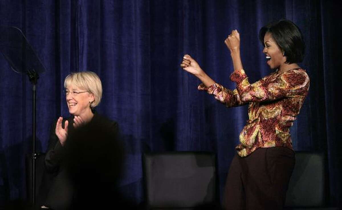 First lady Michelle Obama, right, cheers Sen. Patty Murray at a Senate campaign fundraiser in Bellevue. (AP Photo/Elaine Thompson)
