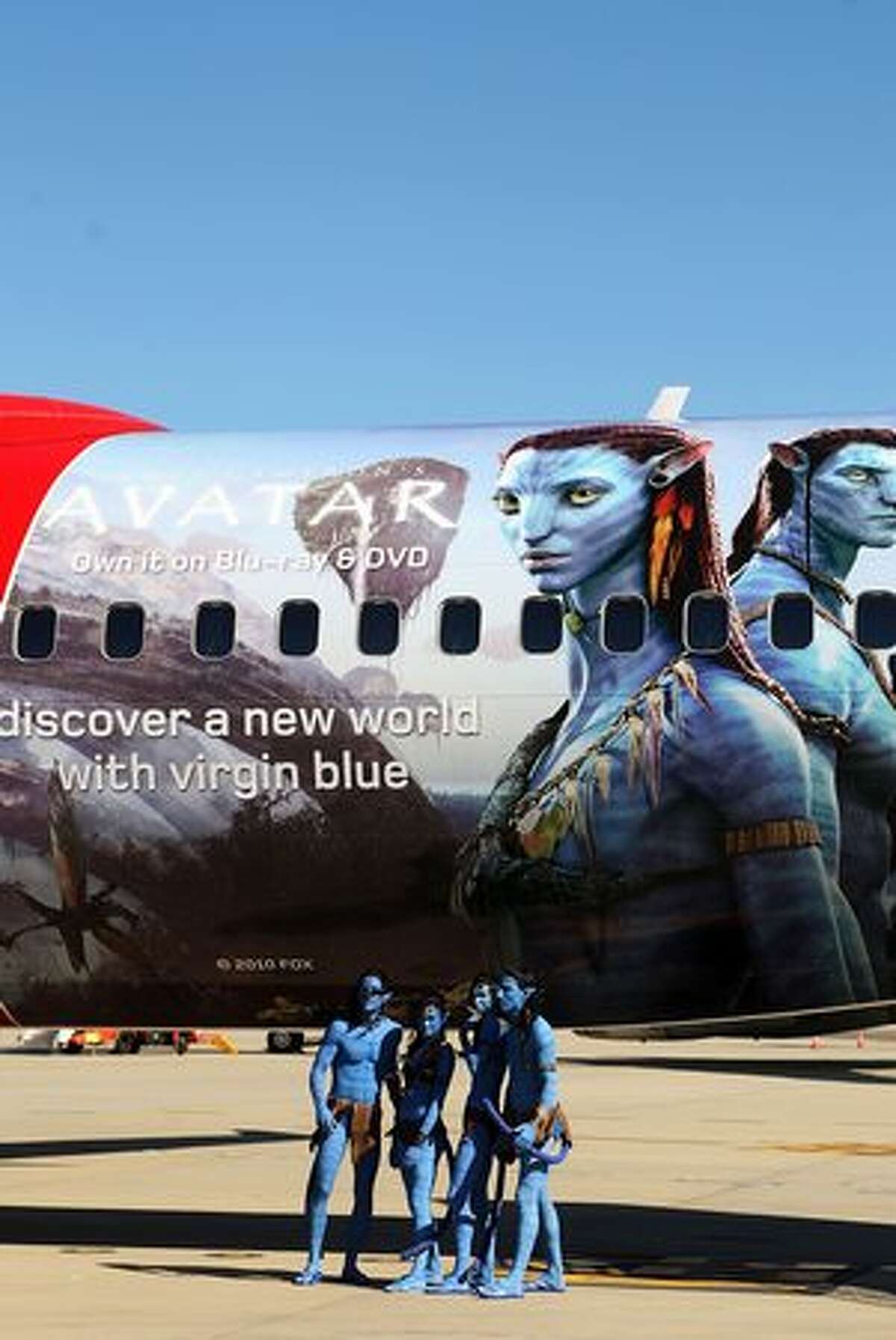 Models dressed up as characters from the film "Avatar" pose in front of an Avatar-themed Virgin Blue Boeing 737 during the launch of "Avatar" Blu-ray and DVD at Sydney Domestic Airport, in Sydney, Australia.