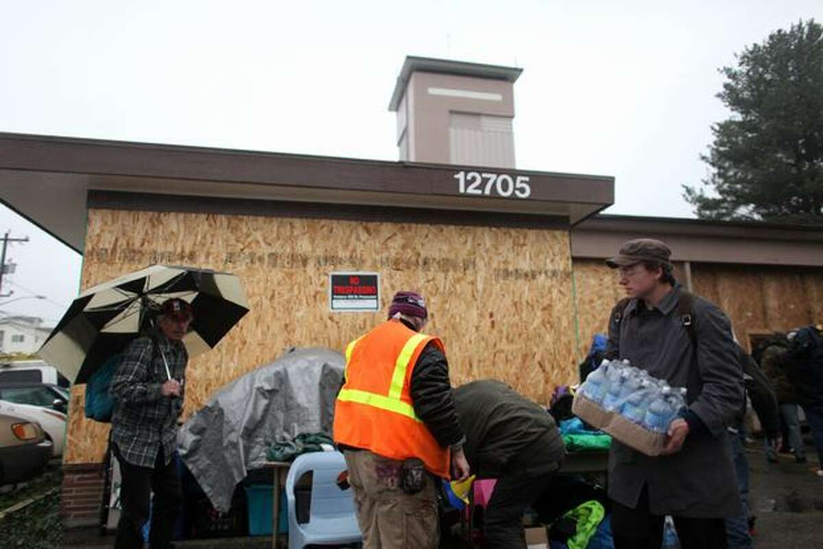 People organize supplies as "Nickelsville" homeless camp residents relocate to Seattle Fire Department's former Station 39 building on Monday, November 15, 2010. The homeless camp, named as a jab at former Seattle Mayor Greg Nickels, relocated to the neighborhood after a stint in the University District. No notice was given to neighbors that the camp was moving there, upsetting some Lake City residents.
