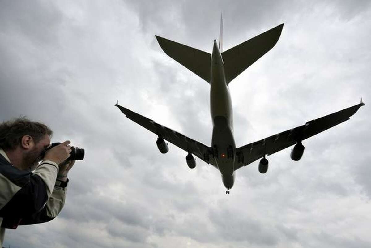 A man takes pictures of an Airbus A380 of German airline Lufthansa flying next to the village of Rheinmuenster, southern Germany, during a landing training for pilots on May 31, 2010 at the airport in Baden-Baden. The German national football team will use this A380 when they travel on June 6, 2010 to South Africa to take part in the 2010 Football World Cup.