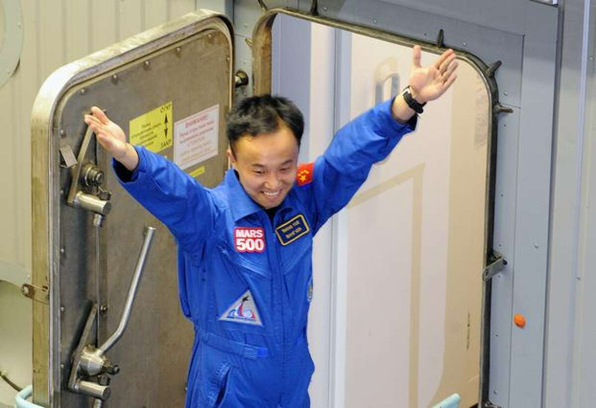 Mars500 crew member Wang Yue, of China, gestures before entering and being locked into the Mars500 isolation facility in Moscow.
