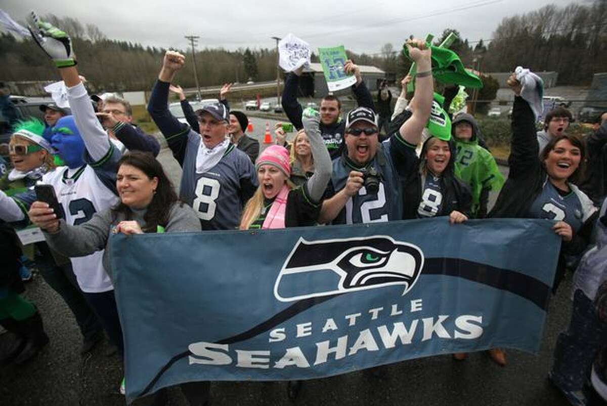 Fans cheer as team busses drive past during a fan sendoff for the Seattle Seahawks.