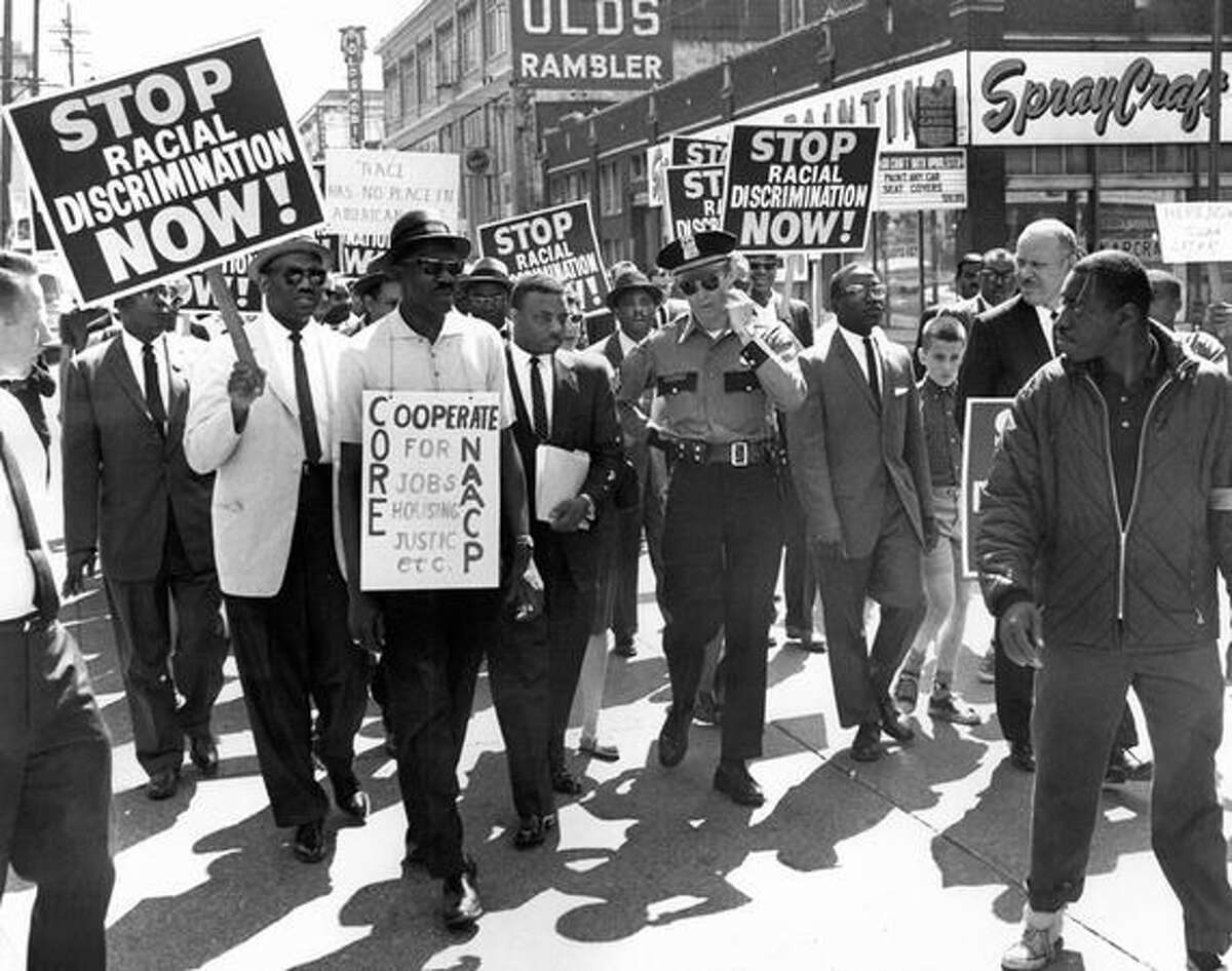 A Seattle march on June 15, 1963. The original caption read: Police Sgt. C.R. Connery chats with Rev. Mance Jackson urging marchers to tighten ranks to avoid traffic problems. (seattlepi.com file)
