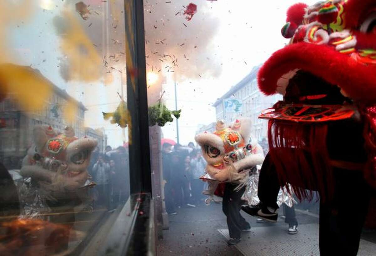 Members of the Mak Fai Washington Kung Fu Club perform a lion dance in front of a business during the Year of the Rabbit Lunar New Year celebration in Seattle's International District on Saturday, Jan. 29, 2011. Crowds braved the rain to participate in the annual event in Seattle.
