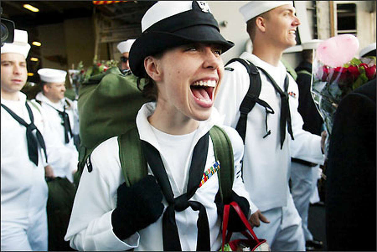 Barbara Silkwood shrieks with delight as she rushes out of Hangar Door 2 on her way to the pier after the aircraft carrier's arrival.Haller: "After being embedded on an aircraft carrier in the Arabian Gulf for nearly a month -– watching the crew go to war against Iraq and seeing the stress they were under -- it was wonderful to see these young sailors come home to Everett. I had rejoined the USS Abraham Lincoln off the California coast in time to cover President Bush's visit to the ship, the arrival in San Diego and the trip back to Everett. As nearly 3,000 sailors rushed down the gangways to a crowd of at least 10,000, it was so nice to see the joy on all the faces."