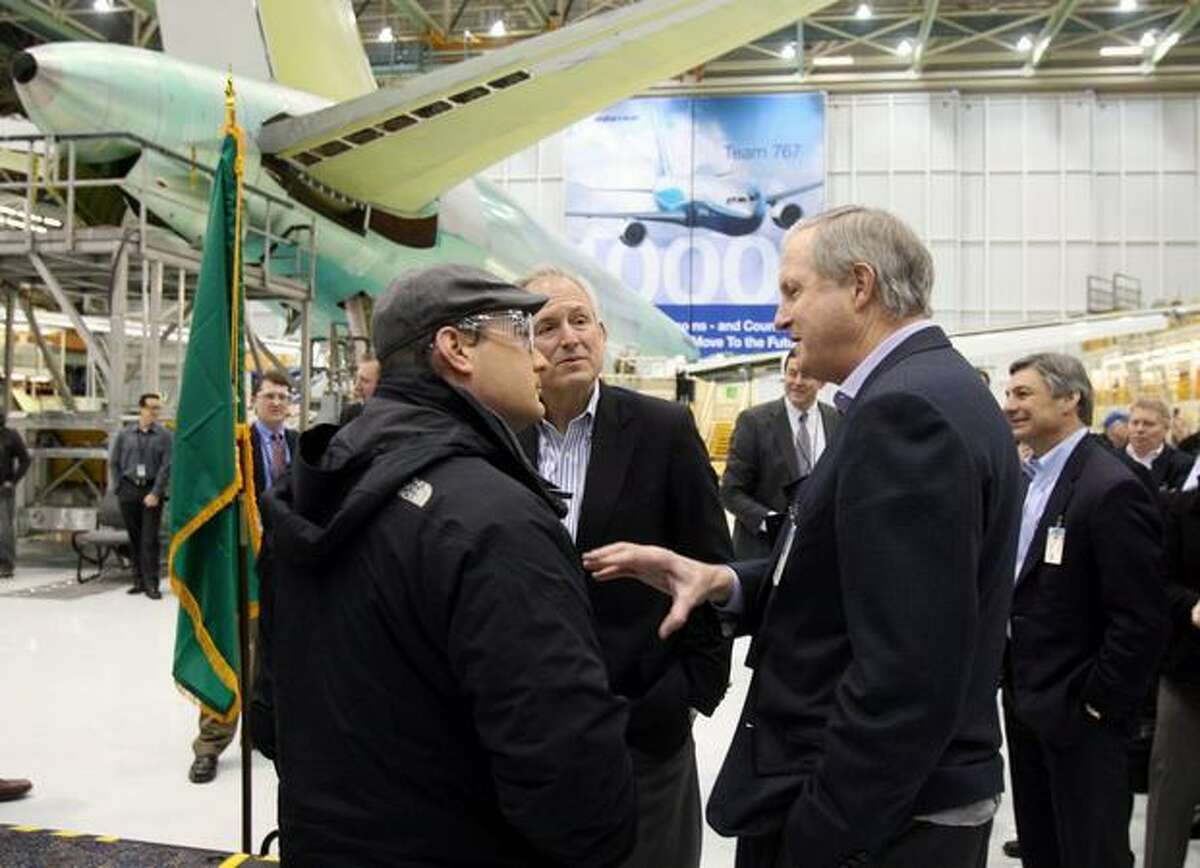 Boeing Commercial Airplanes President and Chief Executive Officer Jim Albaugh (right) and Boeing Chairman, President and Chief Executive Officer Jim McNerney (center) talk with an unidentified Boeing employee before a celebration of Boeing's win of the Air Force's $35 billion aerial refueling tanker contract in Boeing's Everett, Wash., plant.
