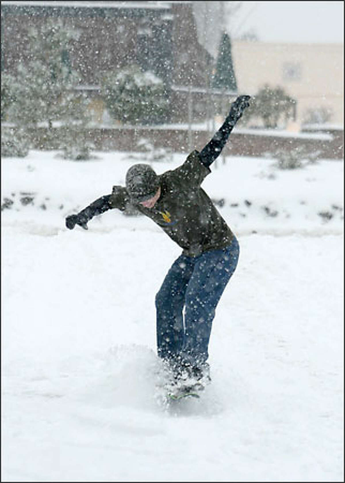 Snowboarder John Webber takes time from his job at Alternative Sports in Puyallup to try out his skills on a Snow Stake in the store's parking lot.