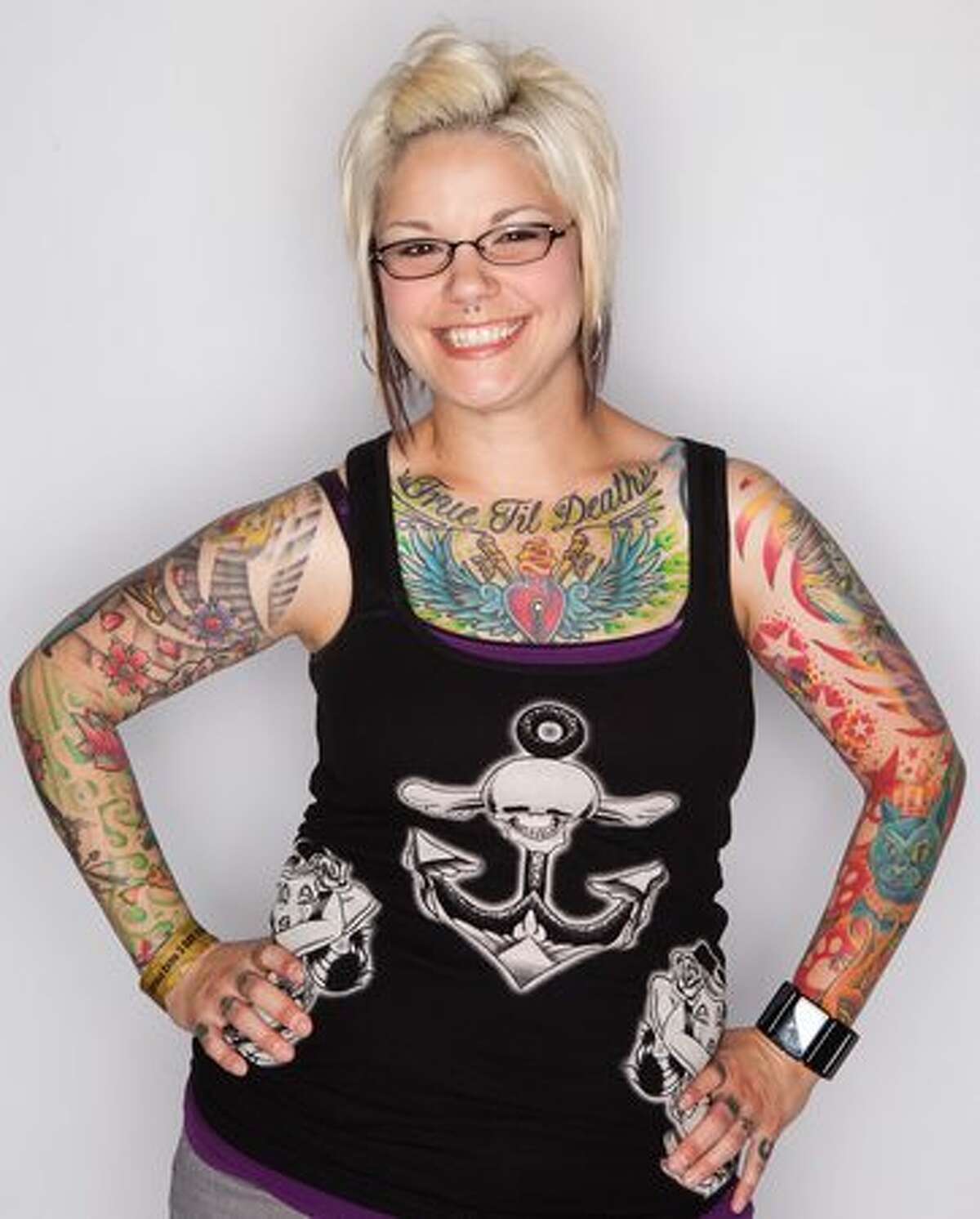 Jodi Campbell shows her tattoos on Saturday at the Tattoo Expo. Campbell is a veterinary technician and some of her tattoos reflect her love of animals.