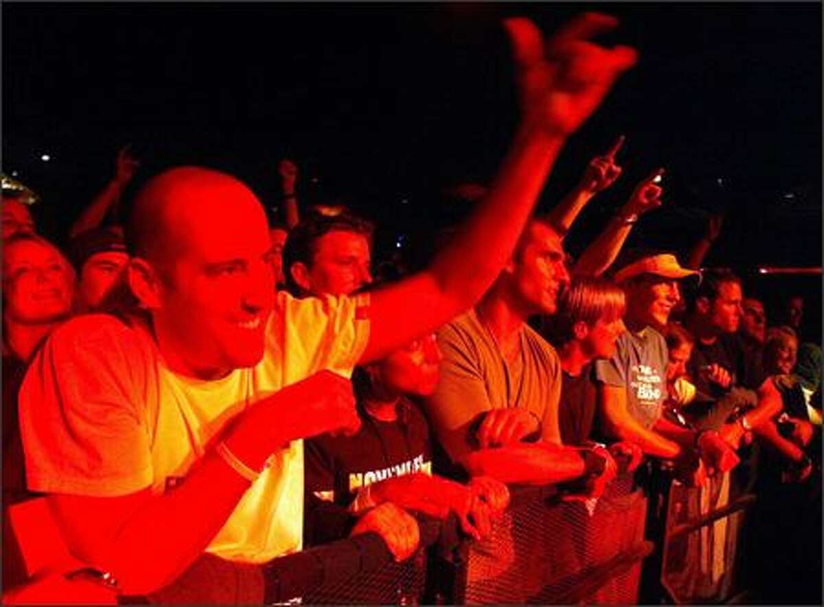 Fans bathed in red light from the stage react to Pearl Jam's performance at the Showbox on Friday night.