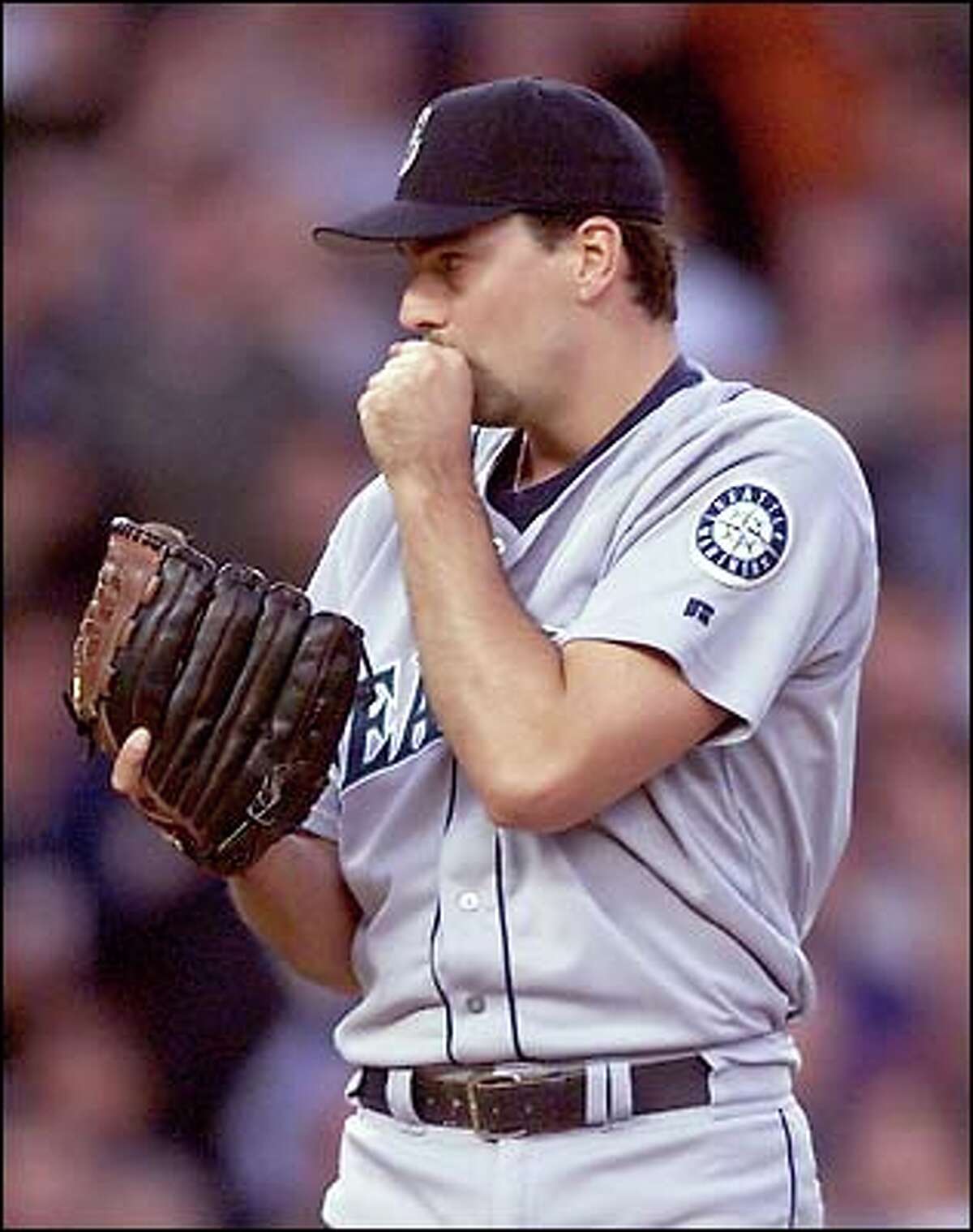 Mariners starter John Halama tries to keep his hands warm between pitches.
