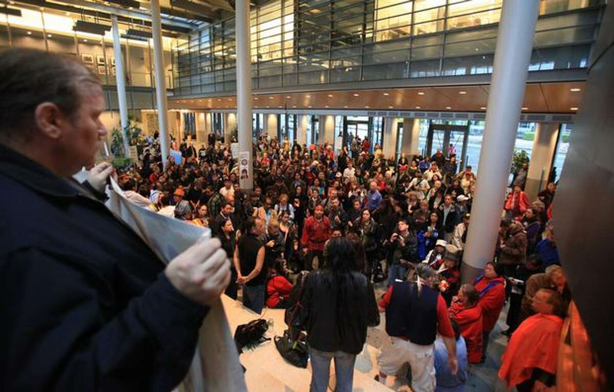 People gather in City Hall during a protest over the recent police shooting of the Native American carver John T. Williams in downtown Seattle. Williams was shot and killed by a Seattle Police officer while holding a knife he did not put down when ordered. Williams used the knife to carve small totems and was deaf in one ear.