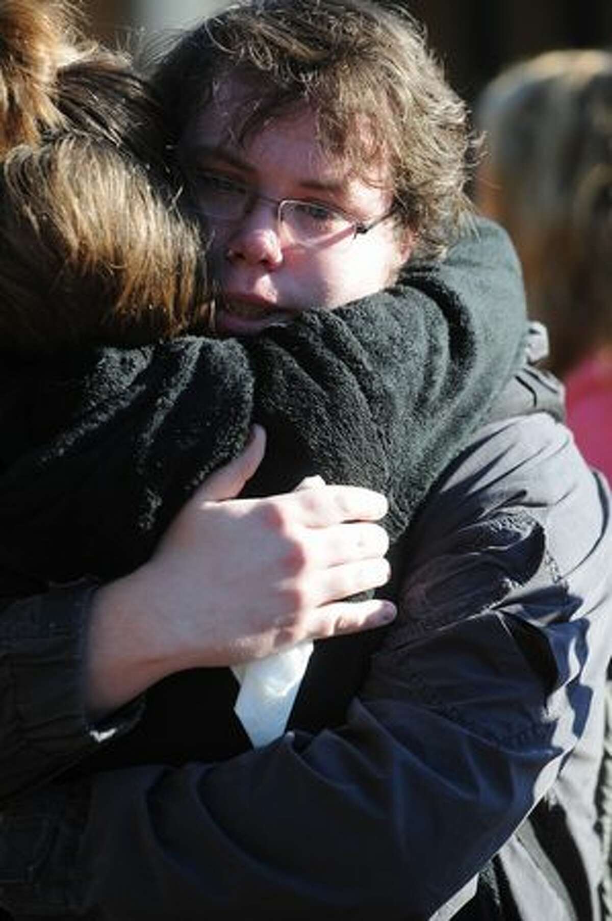Western junior Wyatt Jarvis hugs friend Ashley Hill during a memorial for Dwight Clark, 18, at Western Washington University in Bellingham.