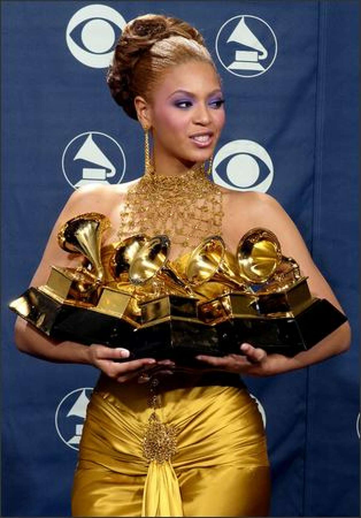 Beyonce Knowles holds the record-tying five Grammys she won during the 46th Annual Grammy Awards. (AP Photo/Reed Saxon)