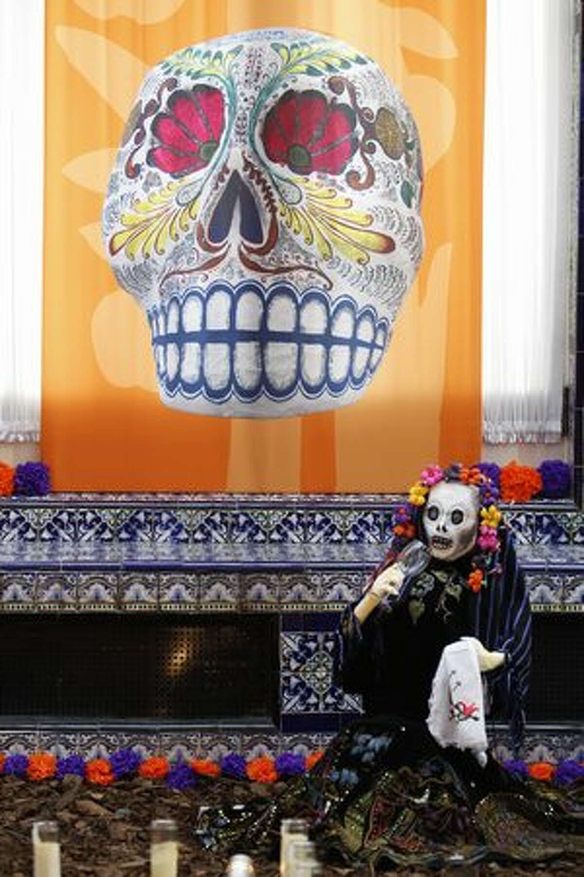 A statue of a skeleton sits near an altar assembled for a Day of the Dead exhibition at the Mexican Cultural Institute in Washington on Sunday in honor of the people who participated in the Mexican Revolution. (AP Photo/Jose Luis Magana)