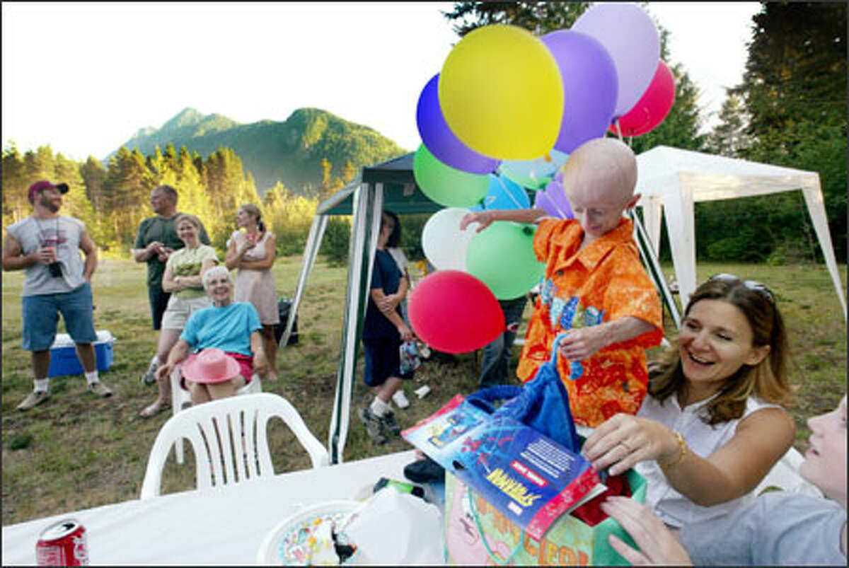 Seth tries to keep balloons at bay while opening gifts with his mother, Patti, at a party celebrating his 11th birthday in July. The party, held at his grandmother's house in Darrington just down the road from his own, was attended by about 40 friends and family members. Everyone in Darrington knows Seth, said his father, Kyle. "Around town, I'm known as Seth's dad."