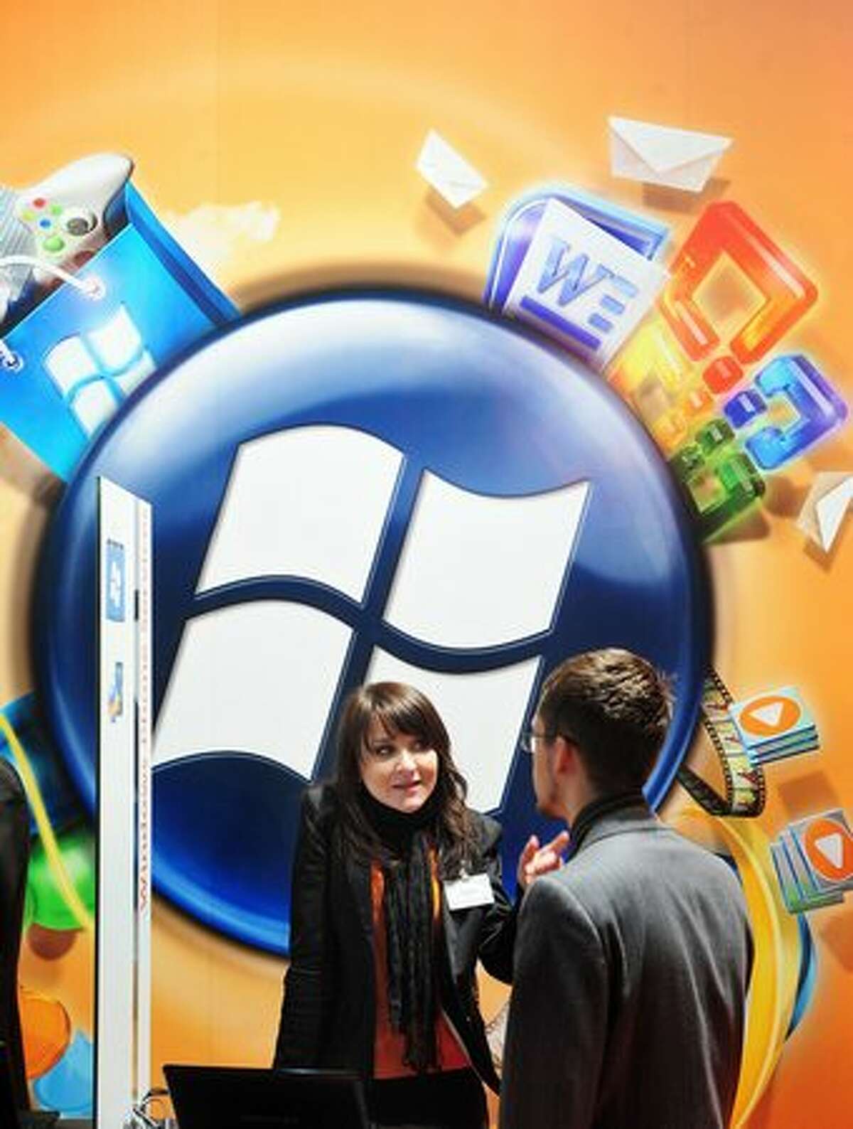 An exhibitor talks to a visitor at the Microsoft stand at the world's biggest high-tech fair, the CeBIT, on March 4, 2010, in Hannover, Germany.