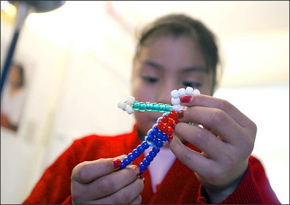 Juanita Salmerson, 10, shows off her bead design during the New Futures after-school program at the Vintage Apartments.