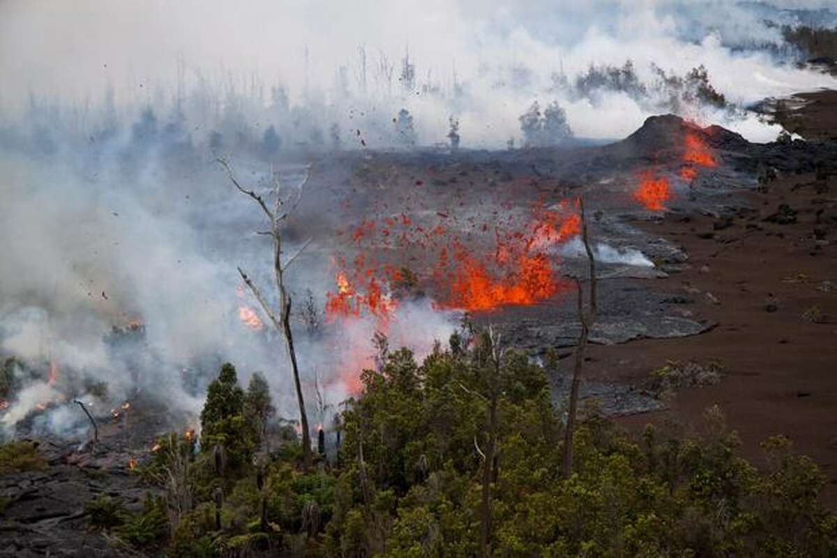 In this photo taken Sunday and provided by the U.S. Geological Survey, Lava spatters above the fissure just west of the base of Pu'u O'o crater. Scientists are monitoring a new vent that has opened at the Kilauea volcano, sending lava shooting up to 65 feet high. (AP Photo/US Geological Survey)
