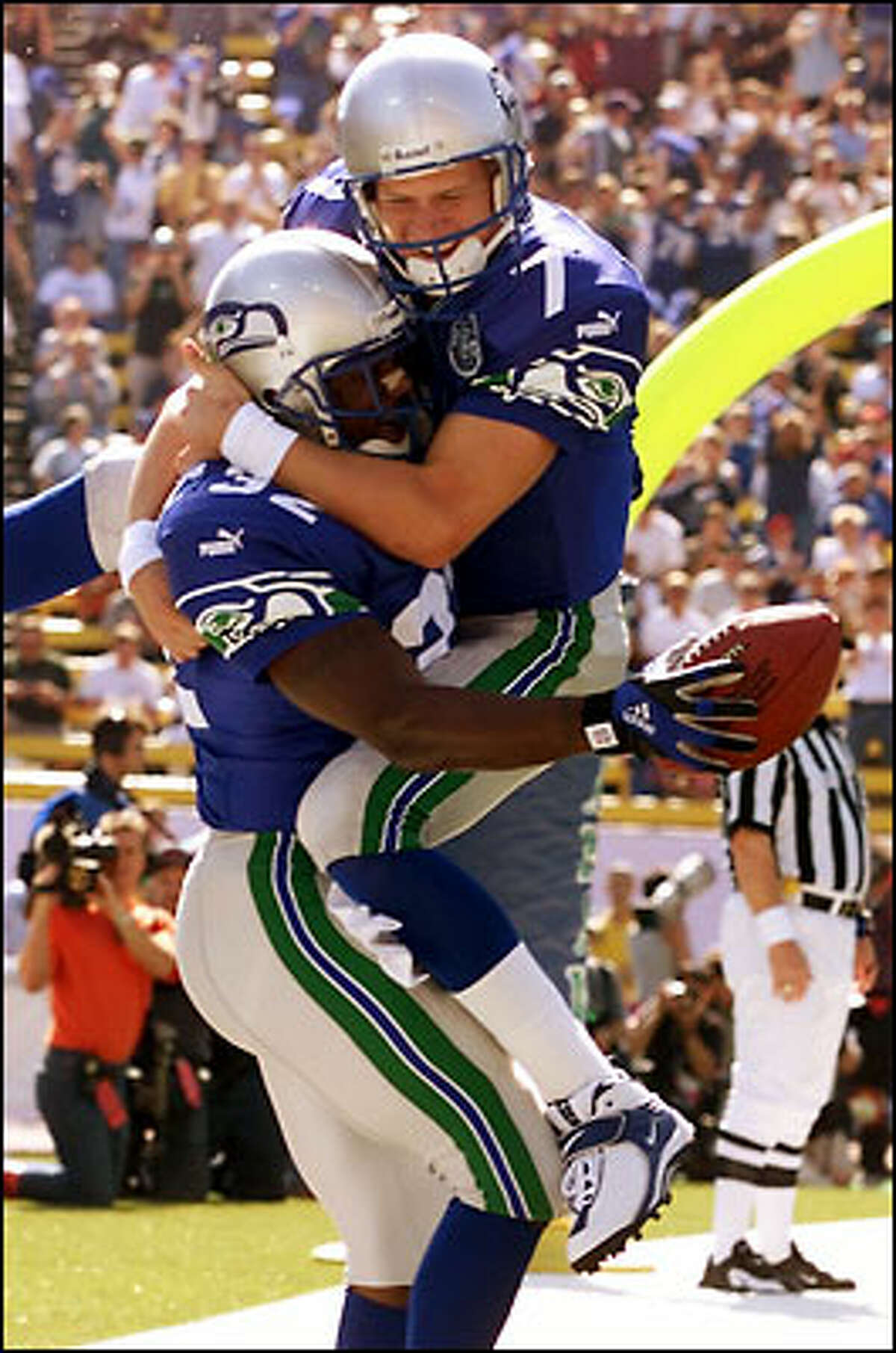 Quarterback Jon Kitna leaps into the arms of running back Ricky Watters after the latter's seven-yard scoring run.