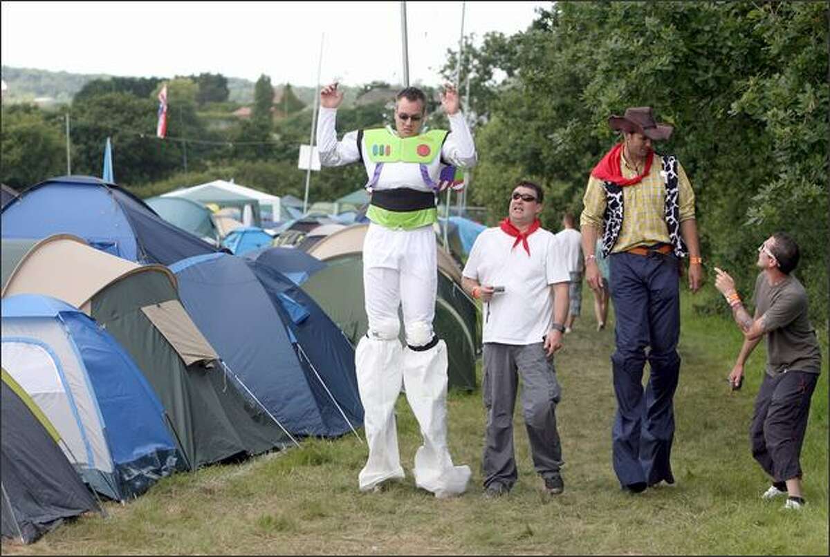 Festival goers dressed as characters from Toy Story walk around the camping fields at the Isle of Wight Festival at Newport in the Isle of Wight, England.