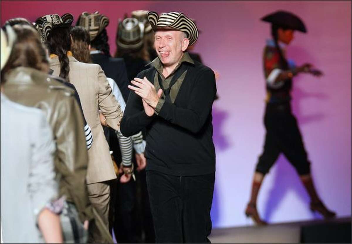 French designer Jean-Paul Gaultier applauds models at the end of the presentation of his collection.
