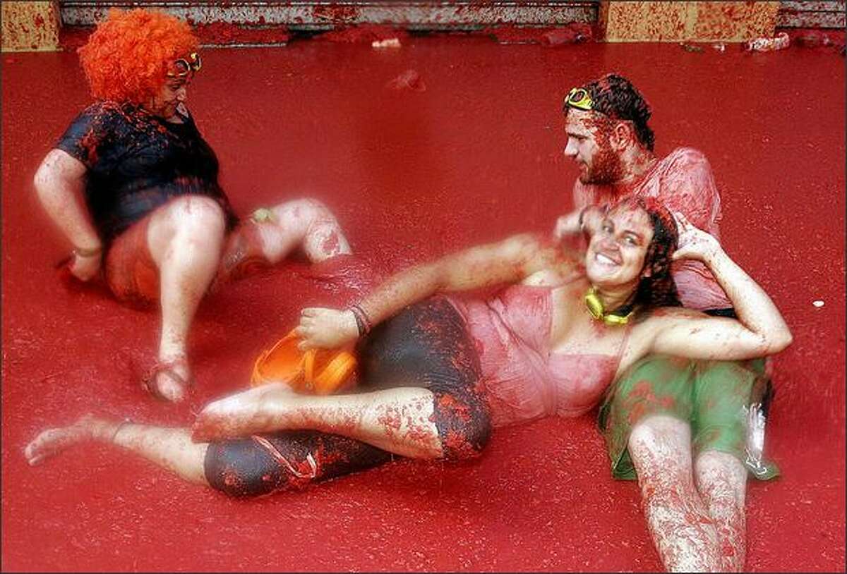 Participants lay in tomato juice during "Tomatina", a traditional festival where people throw tomatoes at each other, on August 27, 2008 in Bunol, some 300km east of Madrid. Tens of thousands of people from around the world hurled tons of ripe tomatoes at each other in an annual food fight that leaves the eastern Spanish town of Bunol covered in red juice. AFP Photo/Pablo ARGENTE