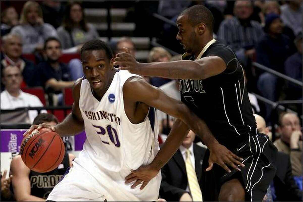 Quincy Pondexter of the Huskies drives on Keaton Grant of Purdue in the first half.