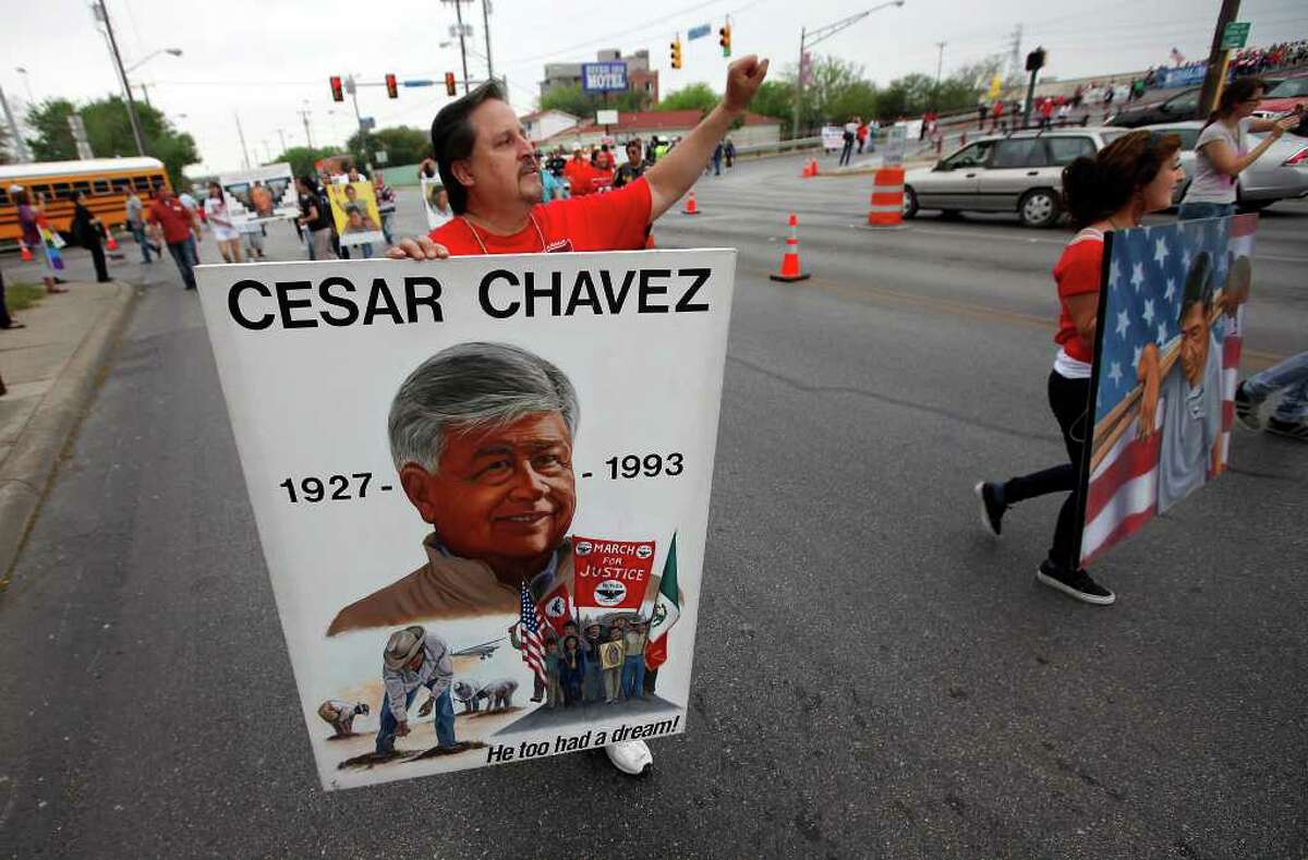 Artist Abel Ortiz gestures as he carries one of his paintings depicting labor and civil rights leader Cesar Chavez during the 15th annual Cesar Chavez March for Justice on Saturday, Mar. 26, 2011. Kin Man Hui/kmhui@express-news.net