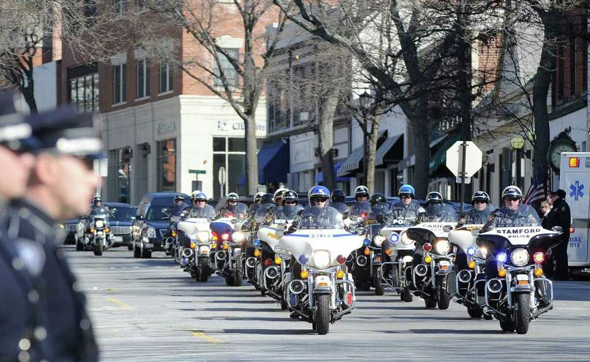 Area motorcycle police lead the funeral procession for Greenwich Police Officer James Genovese on Greenwich Avenue near St. Mary Church, Saturday, March 26, 2011.
