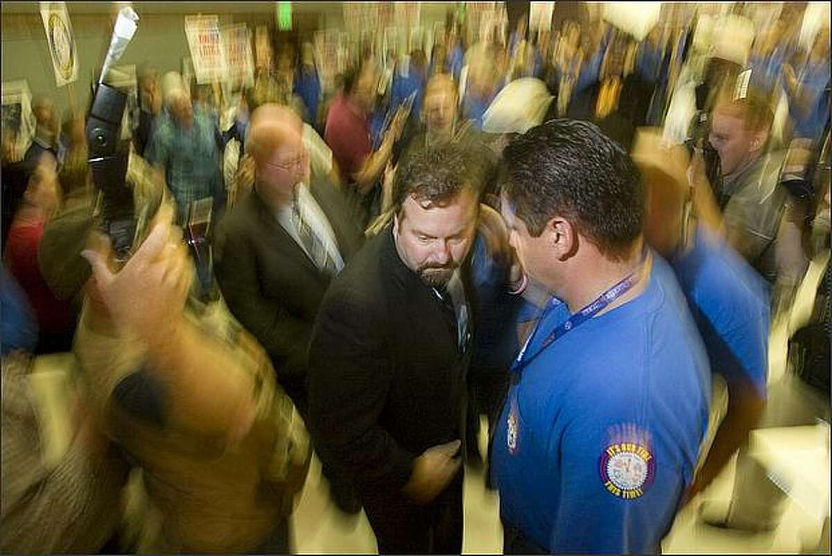 Mark Blondin, chief negotiator, leads the way to the stage, followed by Tom Wroblewski, union president. Members of the International Association of Machinists and Aerospace Workers turned down Boeing's latest contract off and voted to go on Strike but Boeing offered to continue talks and the Union agreed to give them 48 hours to come up with a better offer.