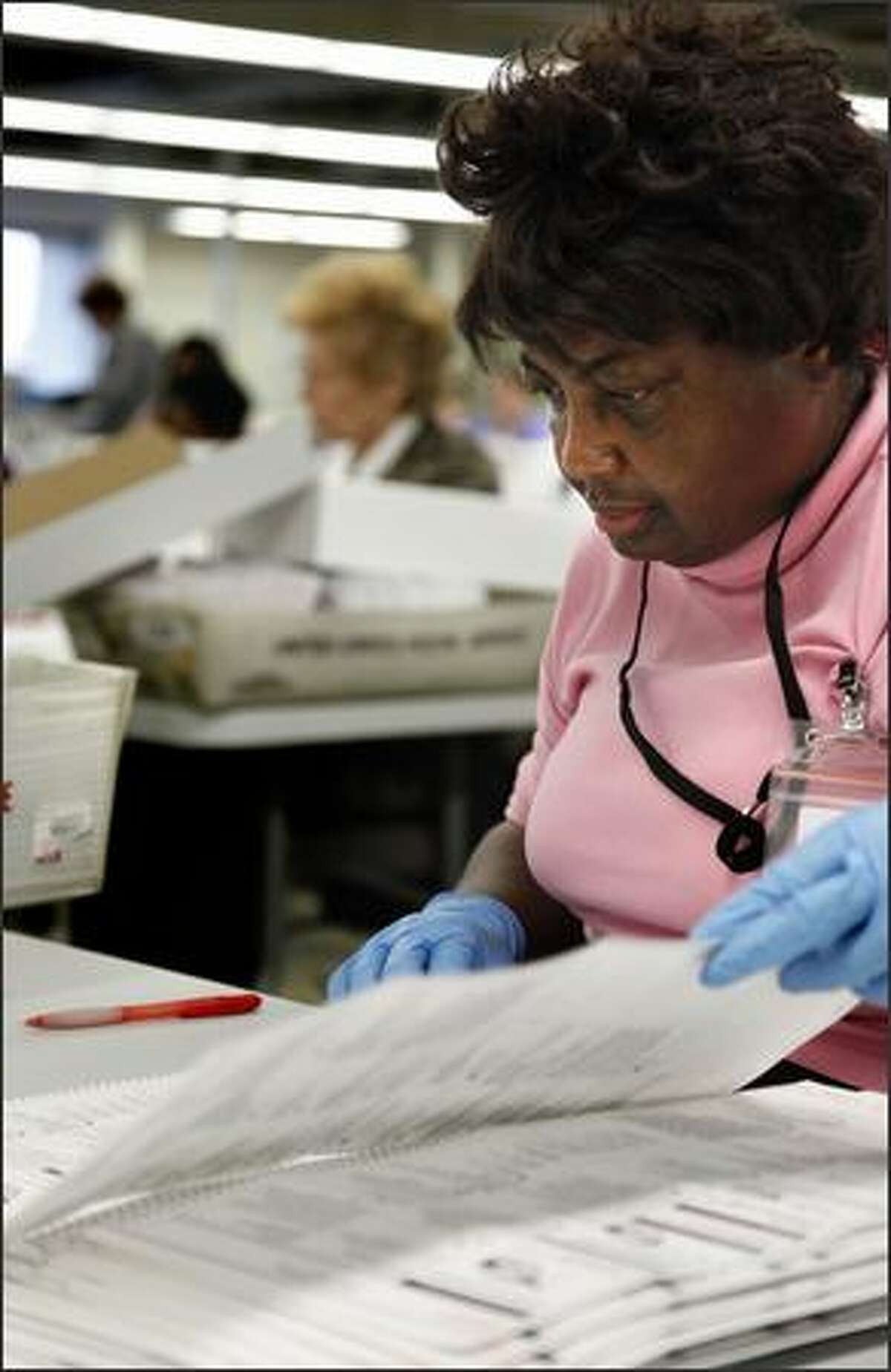 Mary Isabell opens and inspect ballots at the King County Elections office in Renton onTuesday. When done, she seals the opened ballots in a box, then sends it along to be secured and eventually reopened and counted. (Andy Rogers / Seattle Post Intelligencer)