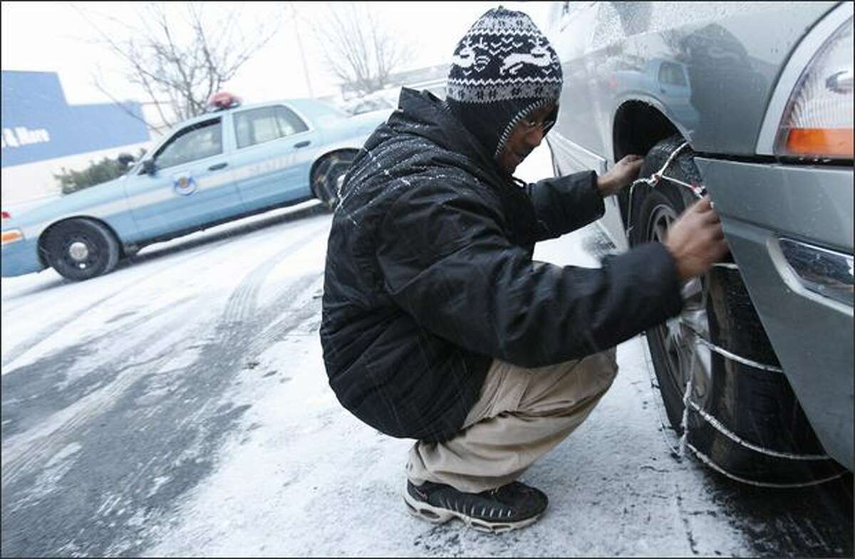 Dave Bajra chains up his minivan outside of Schucks Auto Supply.