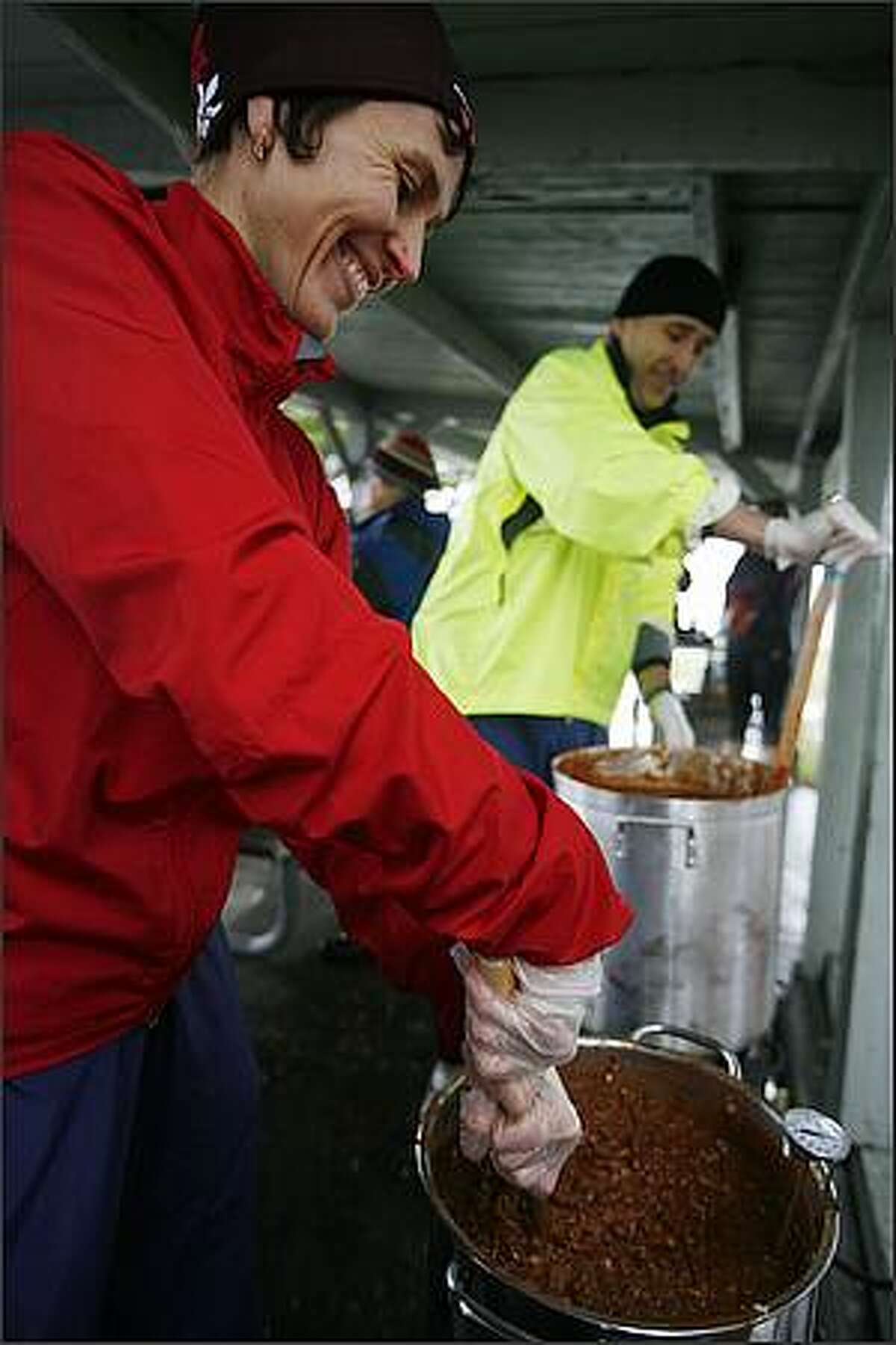 Timea Tihanyi and her husband Sandor Kovacs stir large pots of warm chili on hand for chilly runners participating in the Resolution Run 5K and Polar Bear Dive at Magnuson Park on New Year's Day.
